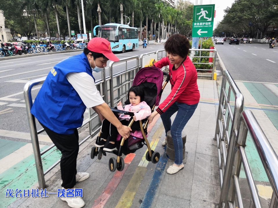 志愿者帮助市民过马路。 茂名日报社全媒体记者 李颜东 摄.jpeg