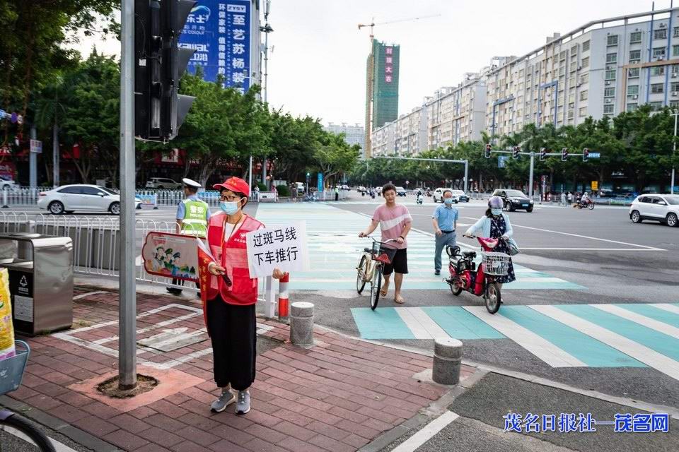 志愿者引导市民文明通过斑马线。茂名日报社全媒体记者吴昊摄.jpg