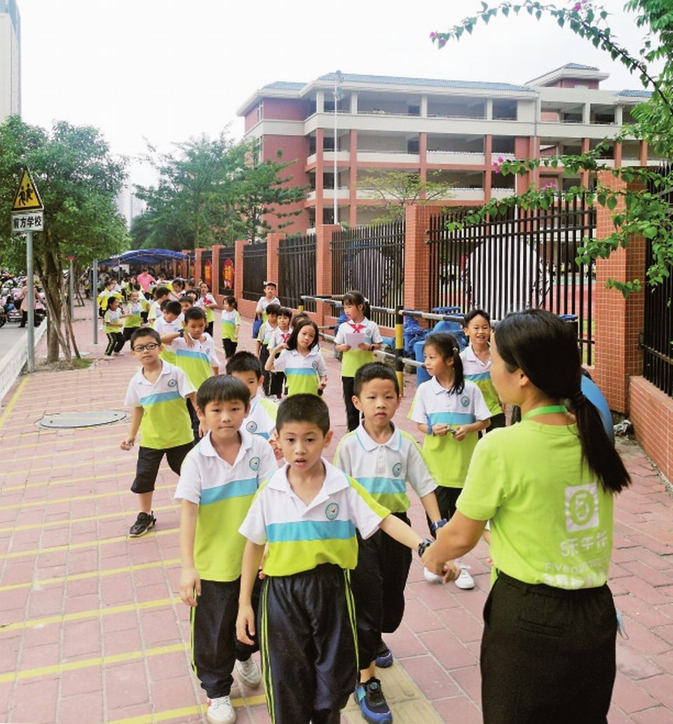 4育才小学的老师护送学生文明有序过马路。.jpg